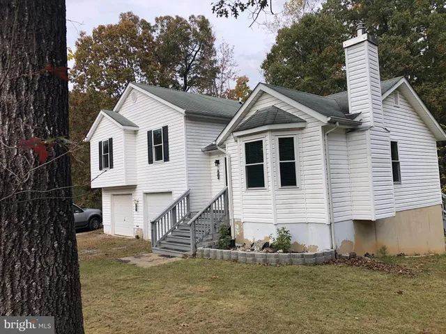 a view of a white house with large windows next to a road