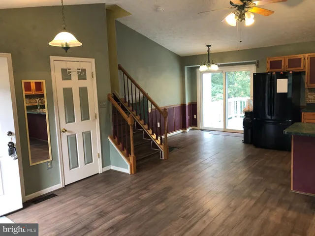 a view of a livingroom with wooden floor and stairs