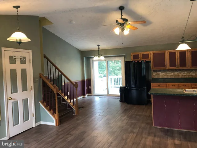 a view of kitchen with a refrigerator cabinets and a ceiling fan
