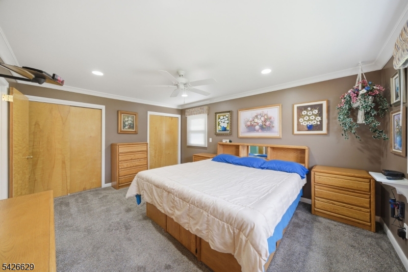 42 Schoolhouse Road Randolph, NJ 07869 - Photo 15 of 49 a bedroom with a bed and a chandelier