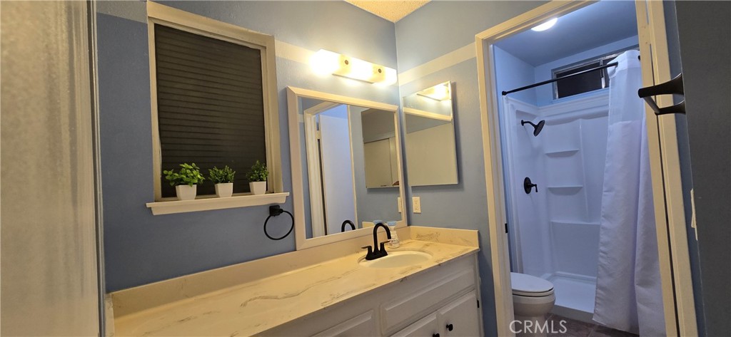 6830 Astoria Drive Riverside, CA 92503 - Photo 20 of 23 a bathroom with a granite countertop sink toilet and shower