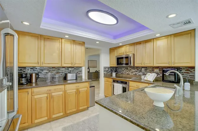 a large kitchen with stainless steel appliances a stove a sink a microwave and dining table