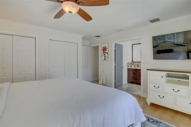 a bedroom with a bed and a flat tv screen on dresser
