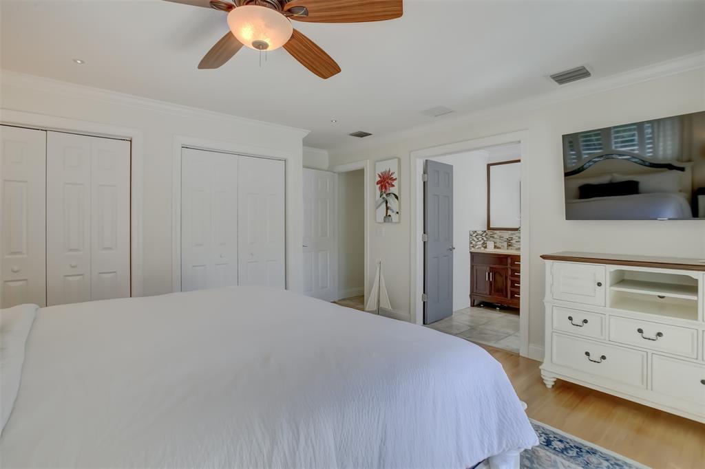 2600 North Riverside Drive Pompano Beach, FL 33062 - Photo 17 of 25 a bedroom with a bed and a flat tv screen on dresser