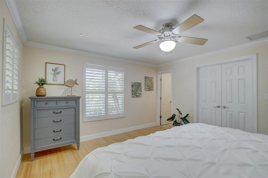 2600 North Riverside Drive Pompano Beach, FL 33062 - Photo 18 of 25 a bedroom with a bed and a chandelier