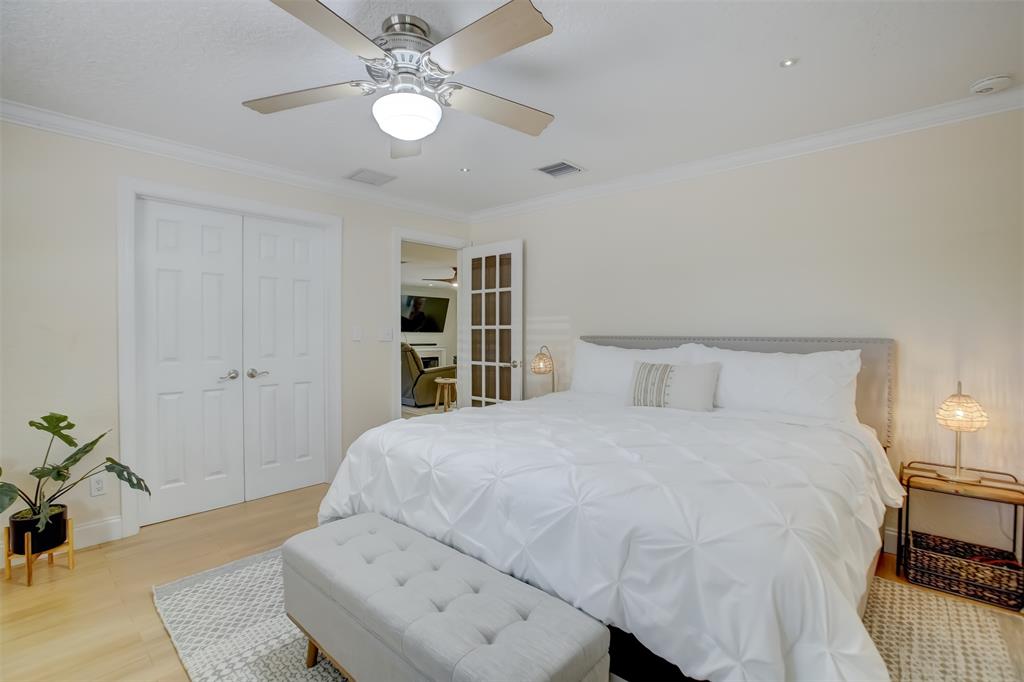 2600 North Riverside Drive Pompano Beach, FL 33062 - Photo 19 of 25 a spacious bedroom with a bed and a chandelier