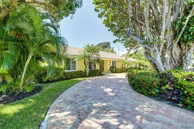 a front view of a house with a yard and fountain in middle