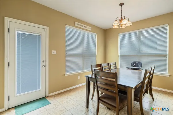 a view of a dining room with furniture and chandelier