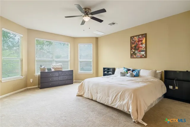 a bedroom with a bed dresser and a window