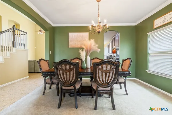 a view of a dining room with furniture and chandelier
