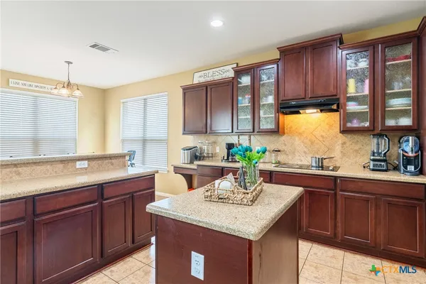 a kitchen with a sink a window and wooden cabinets