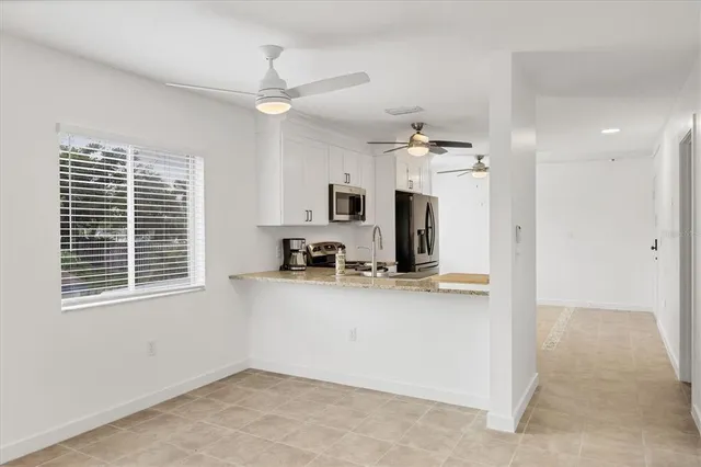 a kitchen with stainless steel appliances granite countertop a sink a stove and refrigerator