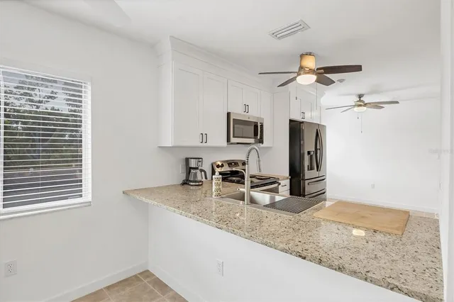 a kitchen with stainless steel appliances granite countertop a refrigerator stove microwave and sink