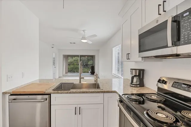 a kitchen with a refrigerator sink and cabinets
