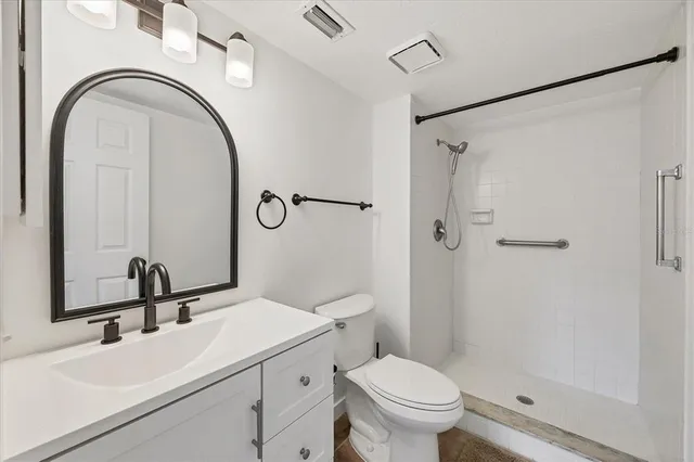 an empty room with windows and kitchen view