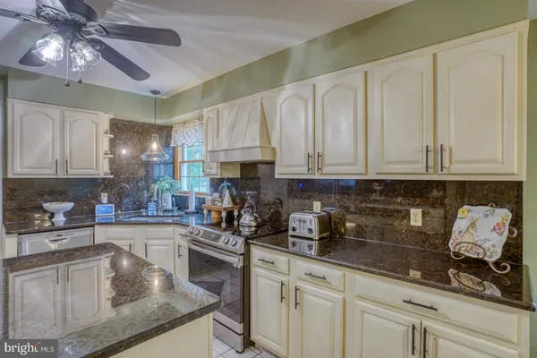 a kitchen with stainless steel appliances granite countertop a sink a stove and cabinets