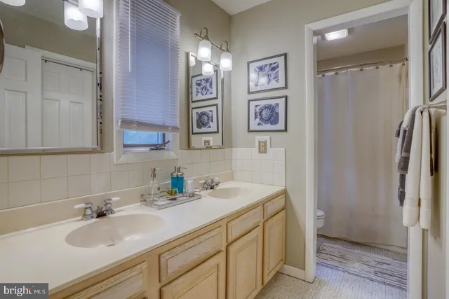 a bathroom with double vanity sink and a mirror
