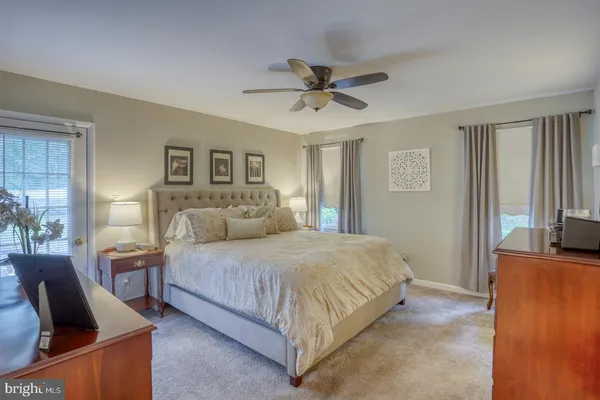 a bedroom with a bed and flat tv screen on the dresser