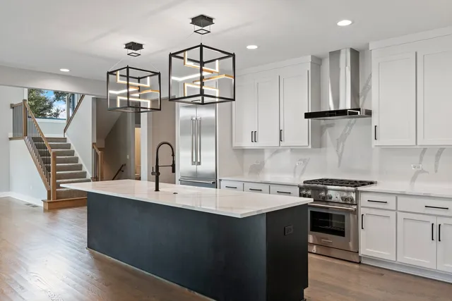 a kitchen with stainless steel appliances granite countertop a sink a stove and a refrigerator