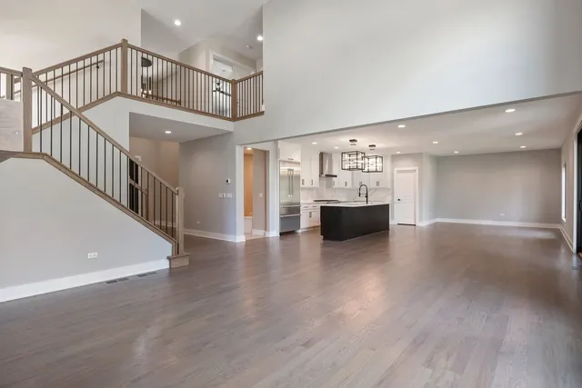 a view of a livingroom with wooden floor and kitchen space with a sink