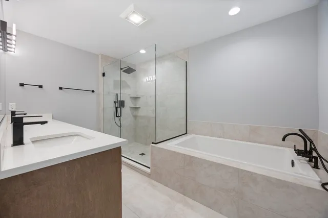 a bathroom with a bathtub sink and mirror