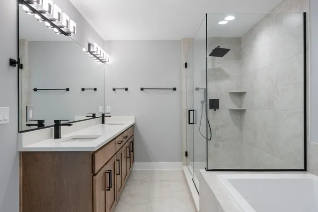 a bathroom with a double vanity sink a large mirror and shower