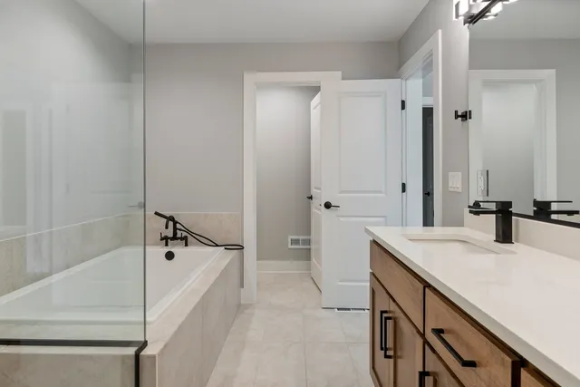 a bathroom with a sink a mirror and a bathtub