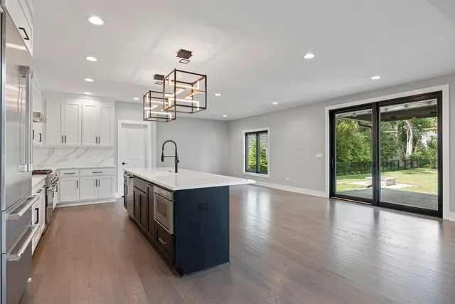 a kitchen that has a lot of cabinets and wooden floor