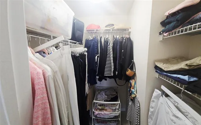 a view of walk in closet with clothes and shoes