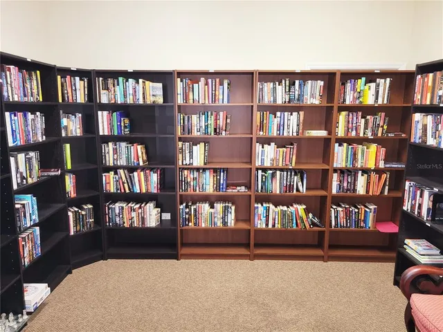 a view of swimming pool with lawn chairs and plants