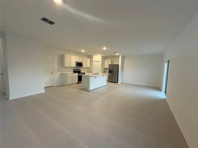 a view of a kitchen with a sink and a refrigerator
