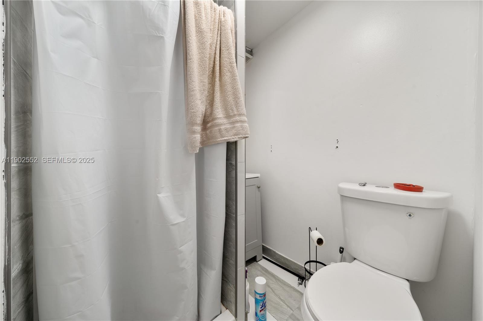 1257 Northwest 58th Street Miami, FL 33142 - Photo 19 of 27 a white toilet sitting next to a shower curtain