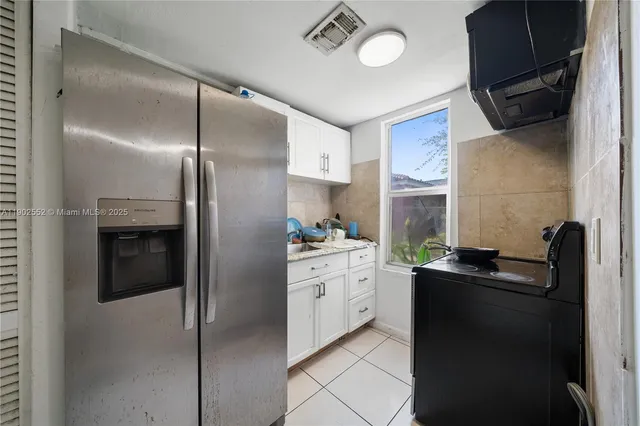 a kitchen with a refrigerator and a sink
