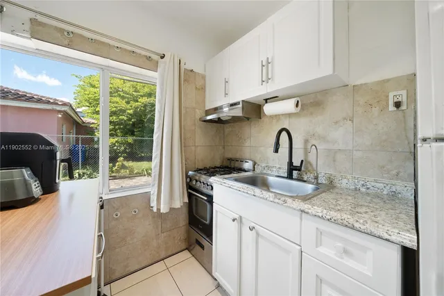a kitchen with a sink stove and cabinets