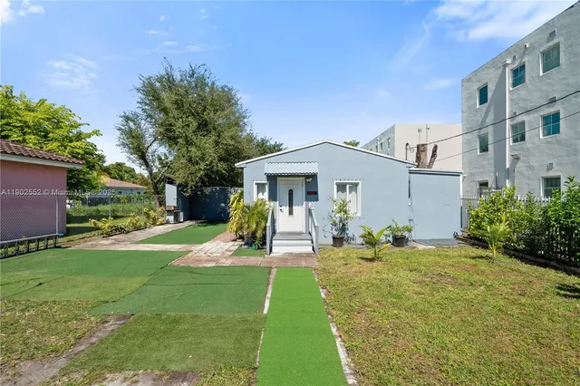 a view of a house with backyard and sitting area