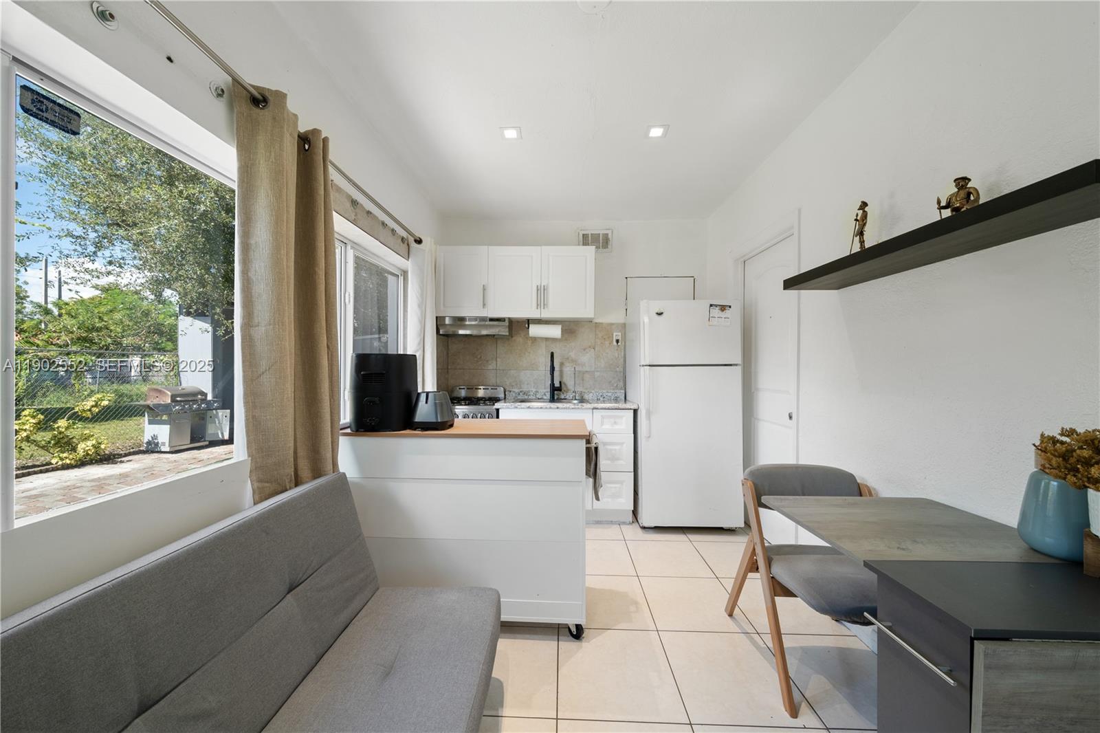 1257 Northwest 58th Street Miami, FL 33142 - Photo 7 of 27 a kitchen with a refrigerator and a stove top oven
