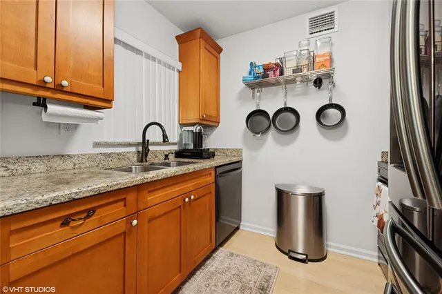 a kitchen with stainless steel appliances granite countertop a sink and a refrigerator