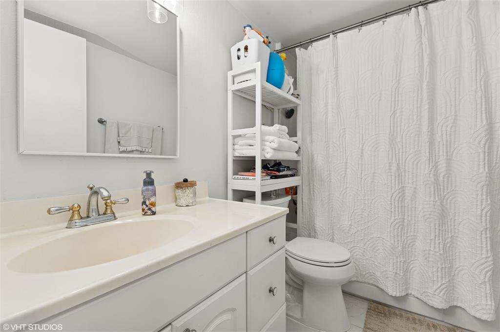 2011 Northeast 32nd Court, Unit 26 Lighthouse Point, FL 33064 - Photo 10 of 13 a bathroom with a sink a toilet and shower curtain