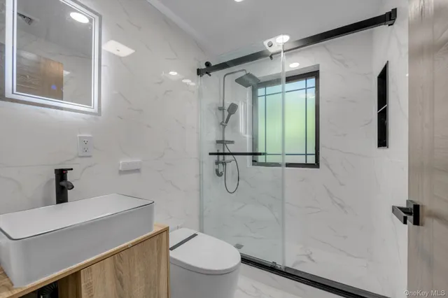 a bathroom with a shower a sink a toilet and mirror