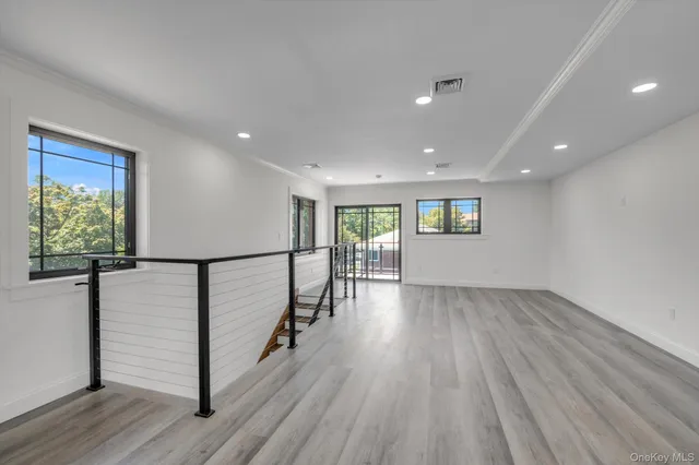 a view of a hallway with wooden floor and stairs