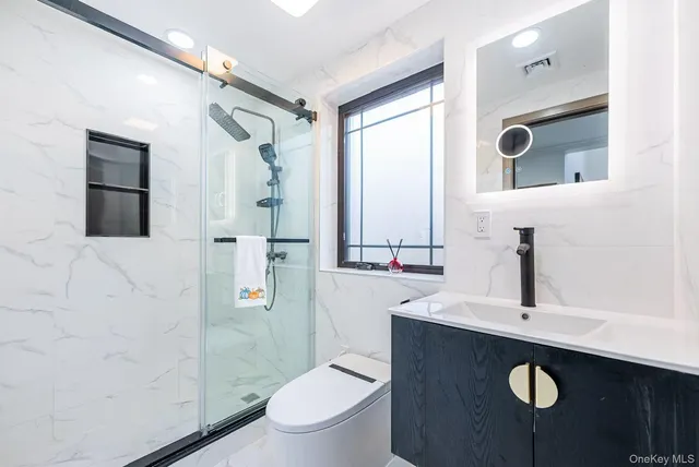 a bathroom with a sink a toilet a shower and mirror