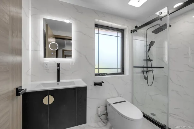 a bathroom with a shower toilet sink and mirror