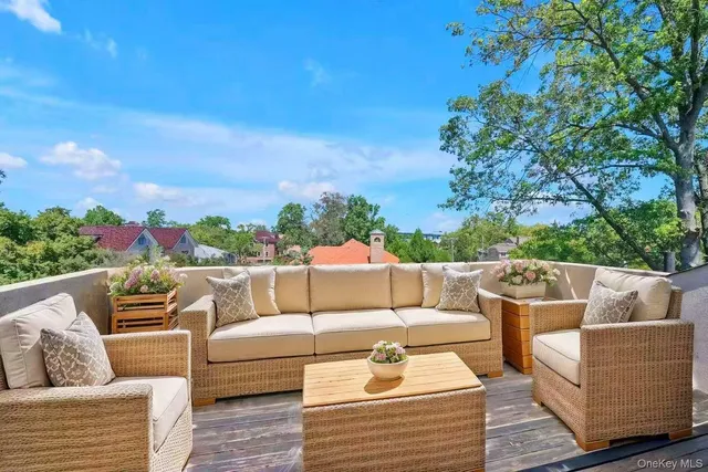 a view of a patio with couches chairs and wooden floor