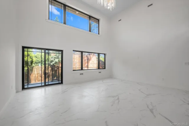 a view of a big room with windows and chandelier fan