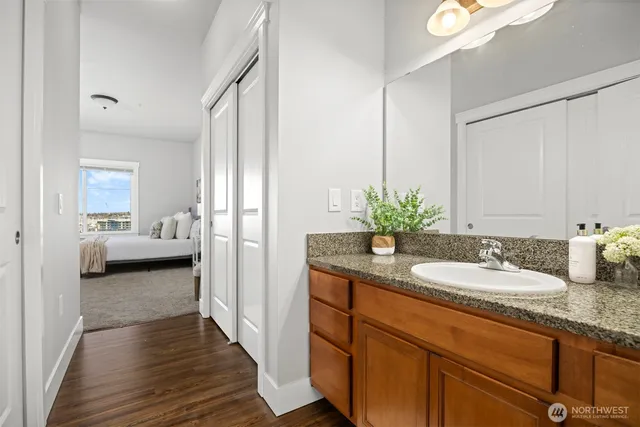 a en suite bathroom with a granite countertop sink and a mirror