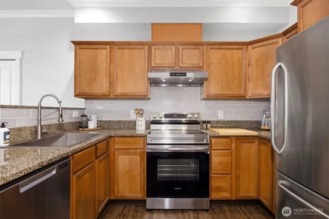a kitchen with stainless steel appliances granite countertop a sink stove and refrigerator