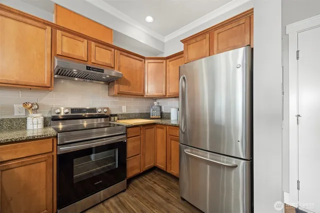 a kitchen with stainless steel appliances granite countertop a refrigerator stove and a sink