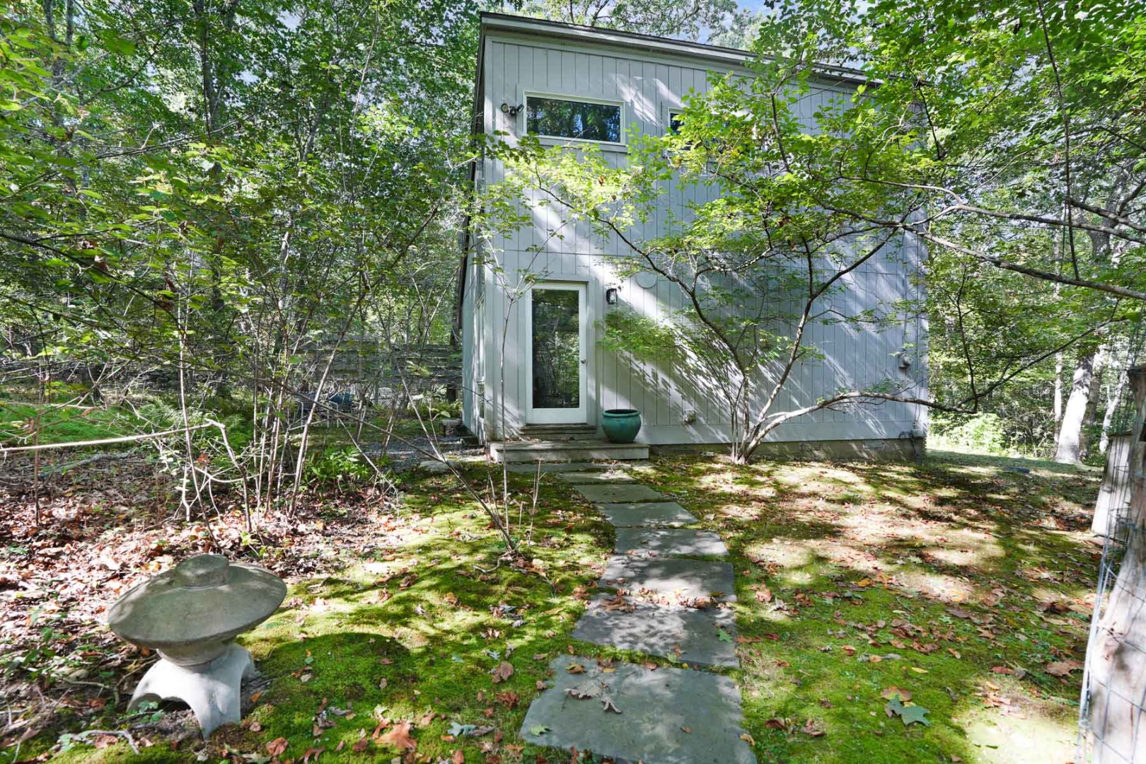 25 Fulling Mill Road Chilmark, MA 02535 - Photo 31 of 31 a backyard of a house with table and chairs under an umbrella