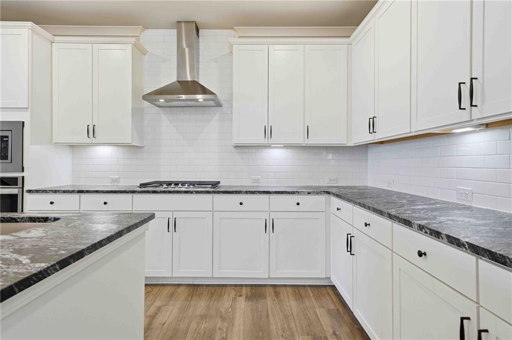 3302 Monarch Avenue Duluth, GA 30096 - Photo 16 of 83 a kitchen with granite countertop white cabinets and a stove top oven