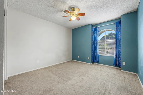 an empty room with windows and painted walls